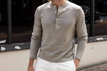 man wearing a long sleeved grey henley shirt and white shorts