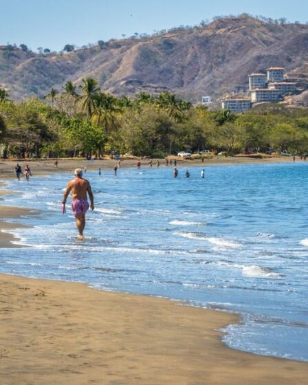 retired man walking along the beach in costa rica