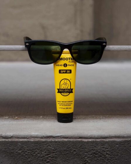 a tube of bee bald daily moisturizer with sunglasses