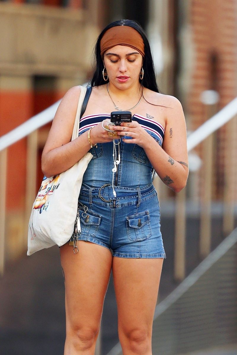 Lourdes Leon turns heads in Tribeca, wearing a trendy denim playsuit with a strapless striped bandeau top, accessorized with a Fendi bag, gold hoop earrings, and white high-top sneakers.