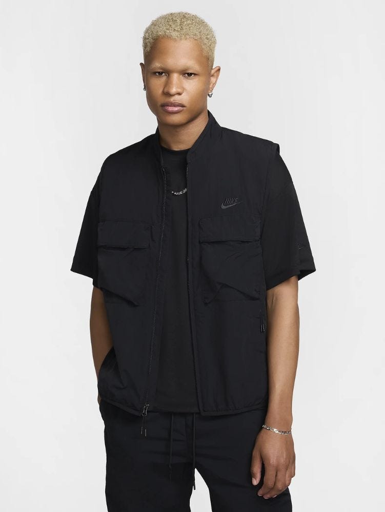 man from the waist up wearing a black Nike vest over a black t-shirt