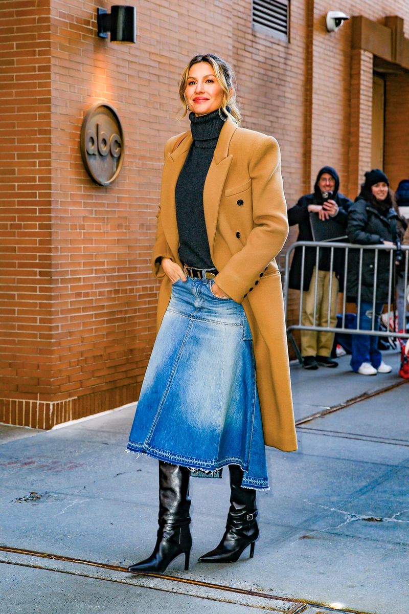 Gisele Bundchen looks stunning in a black turtleneck, a denim skirt, and a brown long coa