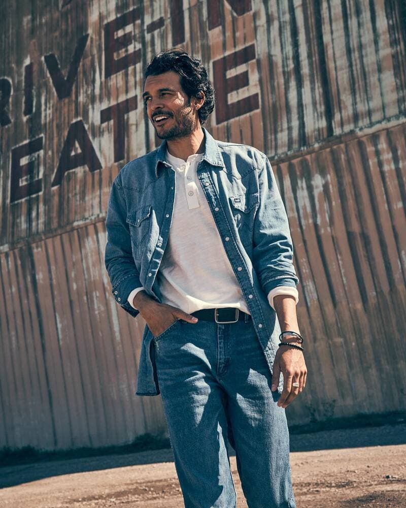 man wearing a wrangler denim shirt paired with jeans