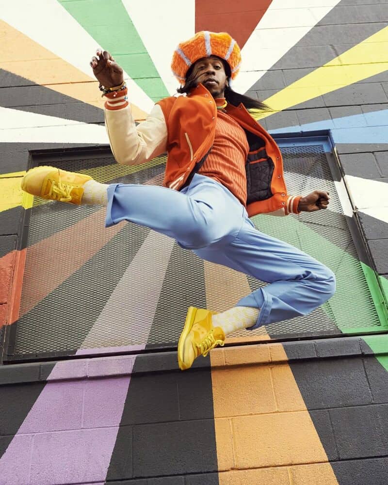 man on a jump wearing a pair of saucony jazz in mustard color