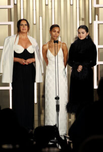 Karla Sofía Gascón, Zoe Saldana, and Selena Gomez speak onstage during the TIFF Tribute Awards during the 2024 Toronto International Film Festival