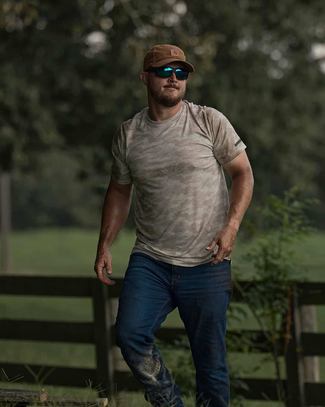 man in a camo t-shirt walking up a small hill