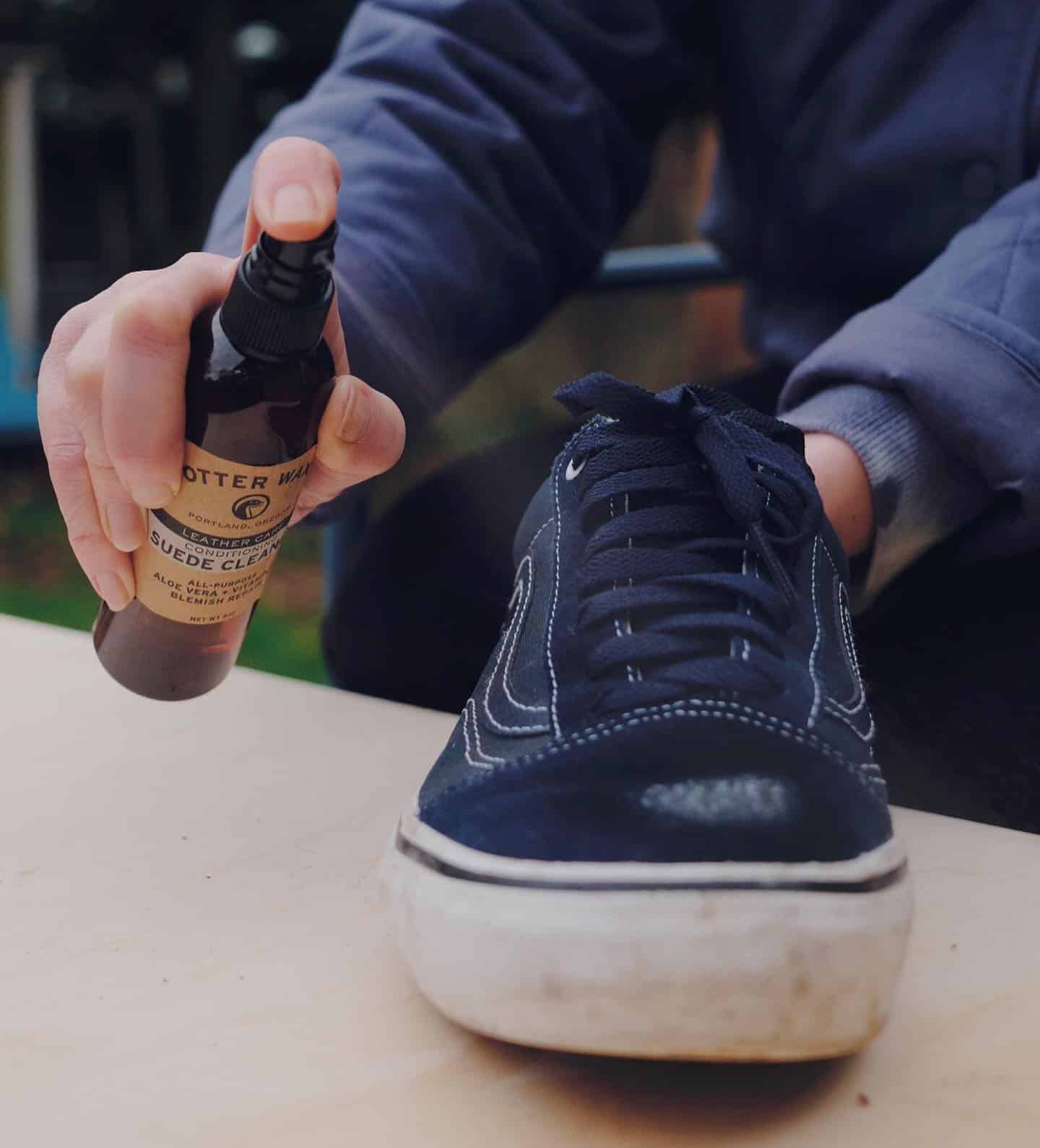 spraying a shoe cleaner on a suede sneaker