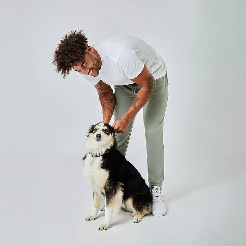 man holding the ears of a pet dog