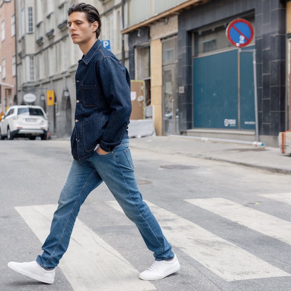 man walking across the road wearing a denim top and bottom