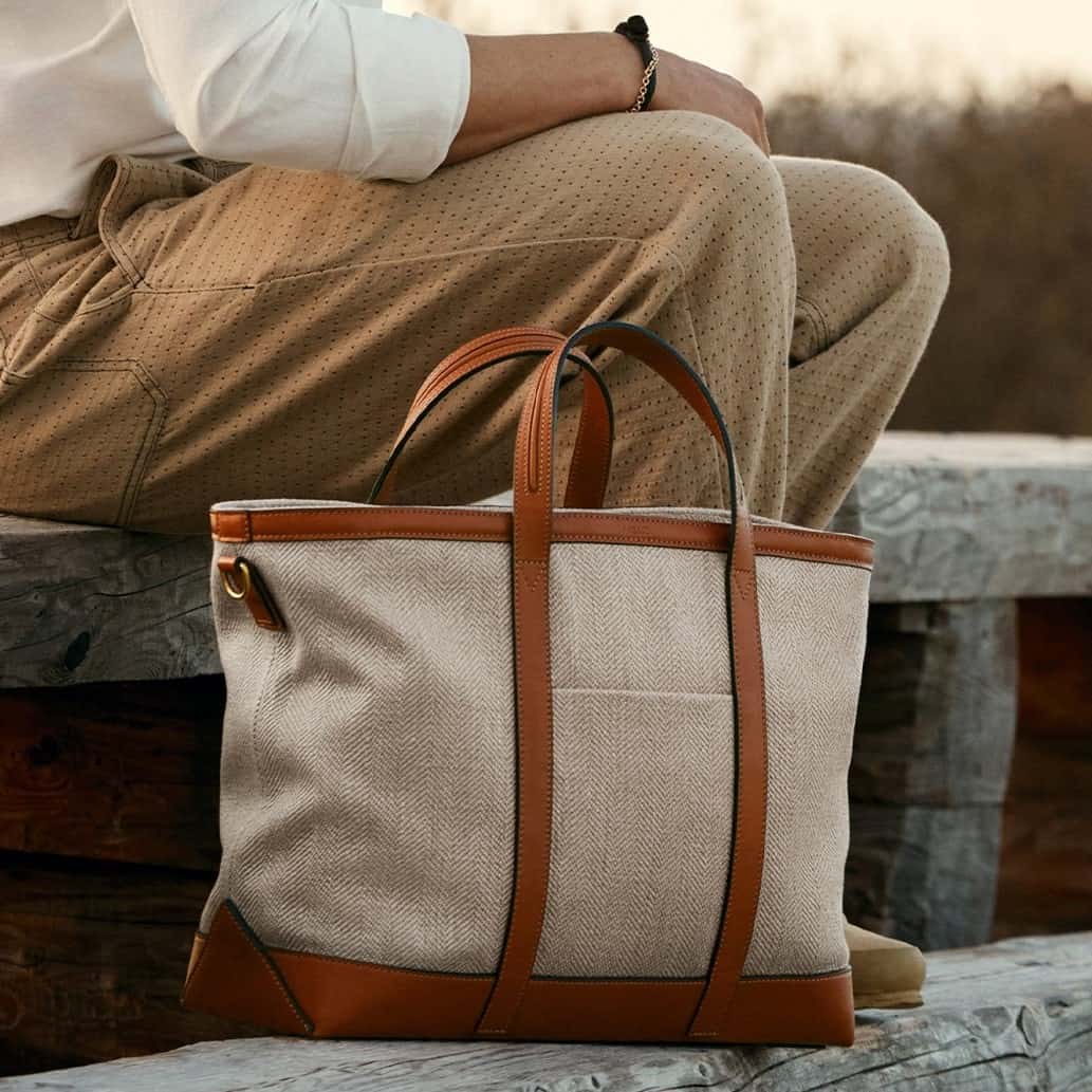 man sitting beside a tote bag