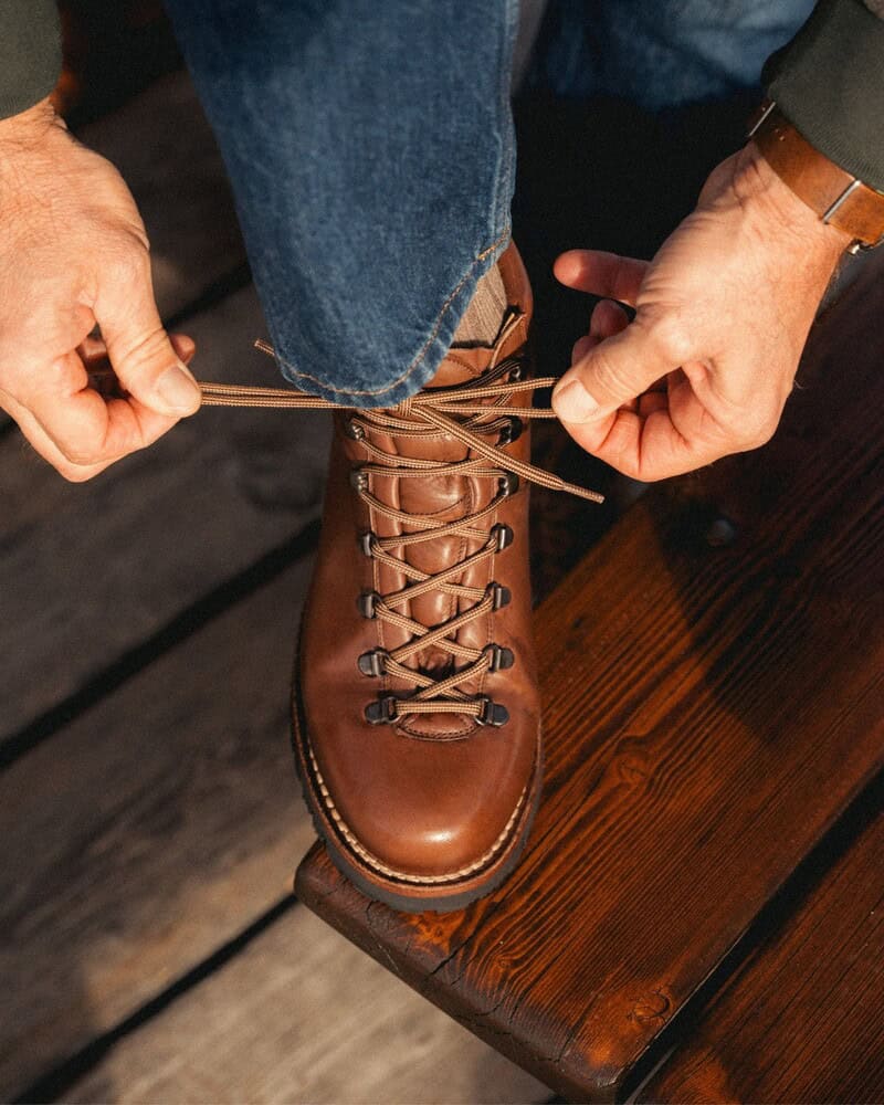 man tying a shoelace of a Velasca Resegott Hiking boots