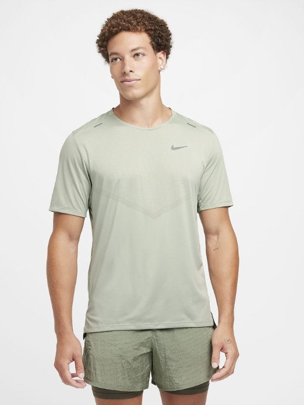 man from the knees up wearing a light green running shirt and green running shorts