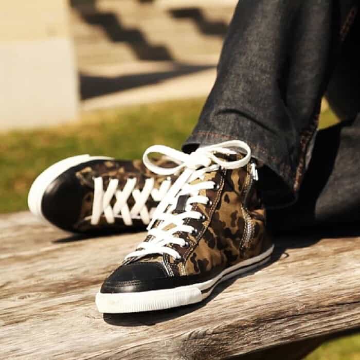 sitting on a bench wearing a pair of Burnetie High Top Vintage Sneaker in Camo