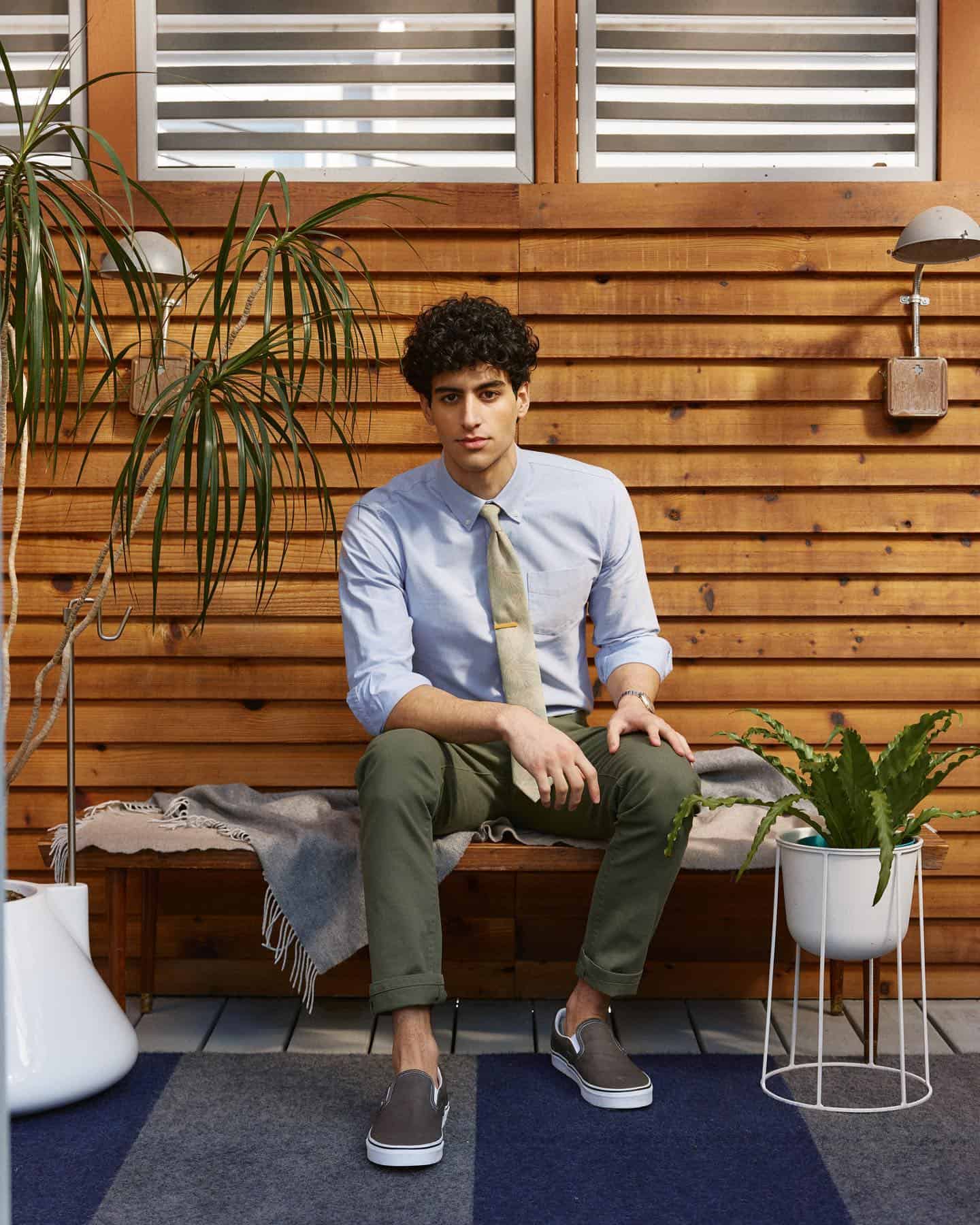 man wearing a light blue shirt and green trousers