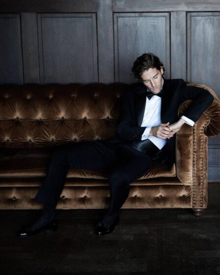 man in a tuxedo sitting on a couch