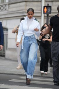 PARIS FRANCE  JULY 02 Tina Kunakey wears gold earrings a white turtleneck long sleeves tshirt a white laces waist...