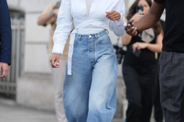 PARIS FRANCE  JULY 02 Tina Kunakey wears gold earrings a white turtleneck long sleeves tshirt a white laces waist...