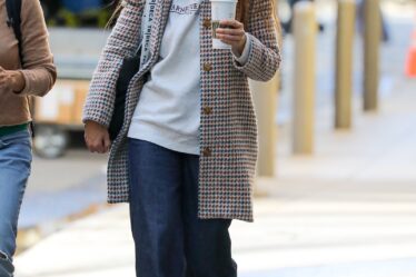 Image may contain Katie Holmes Clothing Pants Pedestrian Person Coat Adult Cup Accessories Glasses and Footwear