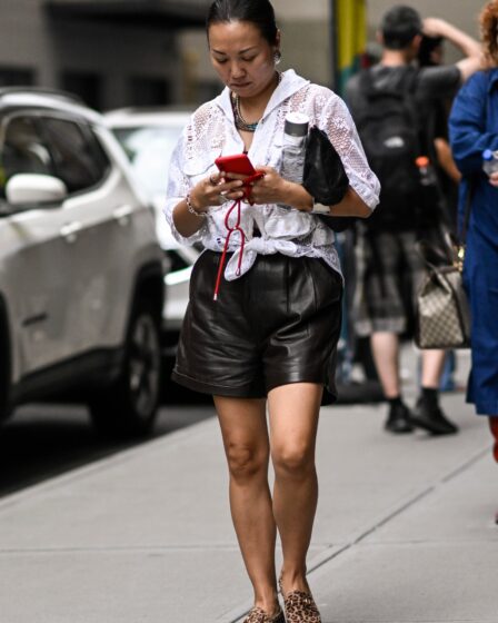 NEW YORK NEW YORK  SEPTEMBER 09 A guest is seen wearing a sheer white button down top black faux leather shorts and...