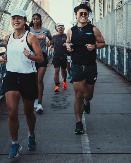 smiling group of young runners crossing a bridge