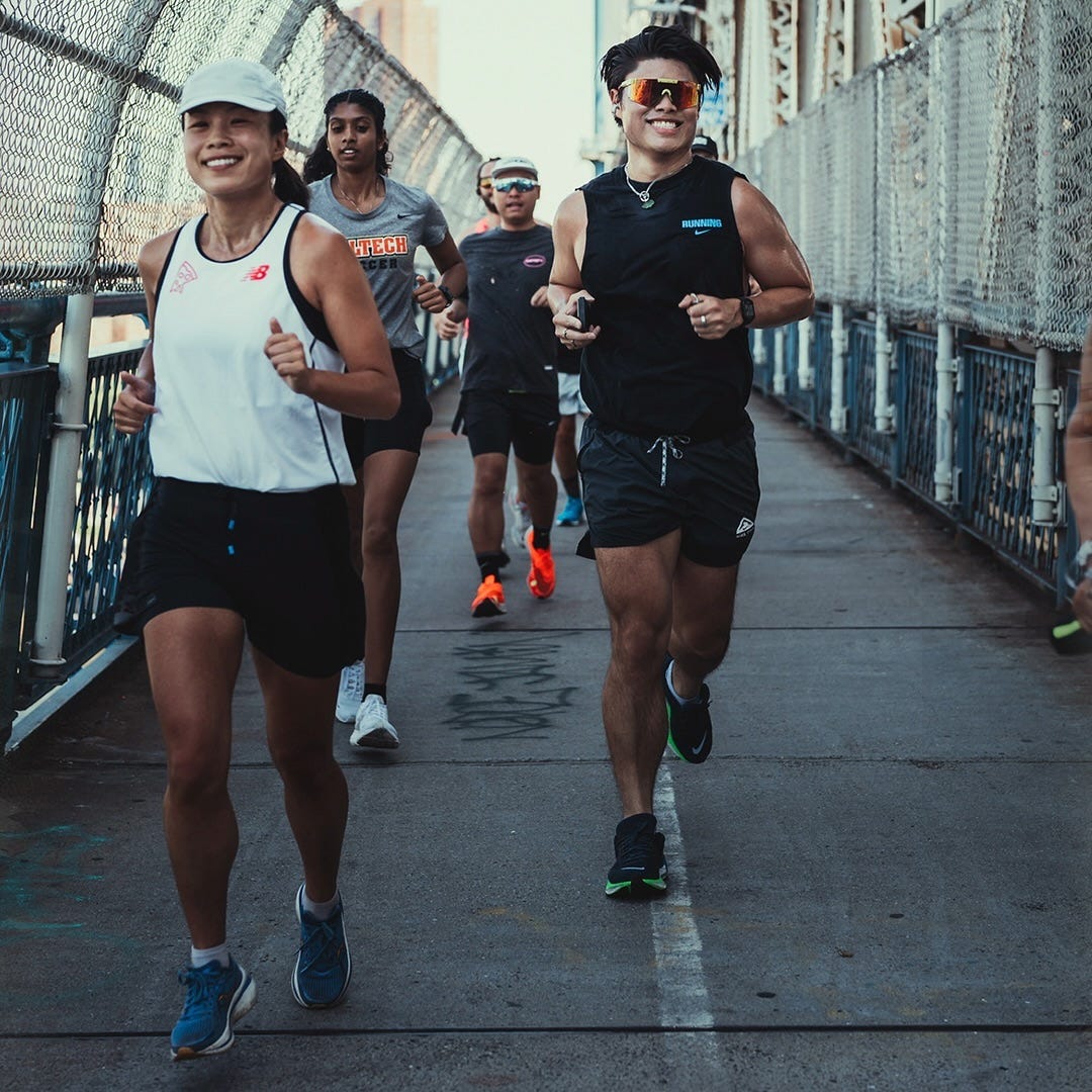 smiling group of young runners crossing a bridge