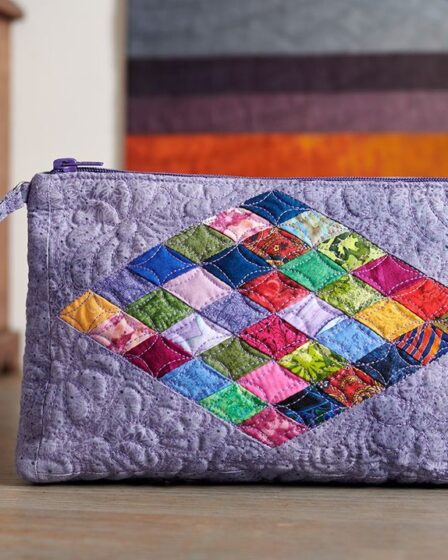 A colorful quilted handbag on a wooden surface