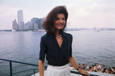 The familiar towers of Manhattan and the not unknown physiognomy of Jacqueline Kennedy Onassis can be made out in the New York Harbor, as she returns to the Big Apple from Staten Island, where she toured the Snug Harbor Cultural Center.