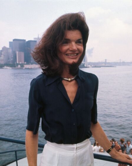 The familiar towers of Manhattan and the not unknown physiognomy of Jacqueline Kennedy Onassis can be made out in the New York Harbor, as she returns to the Big Apple from Staten Island, where she toured the Snug Harbor Cultural Center.