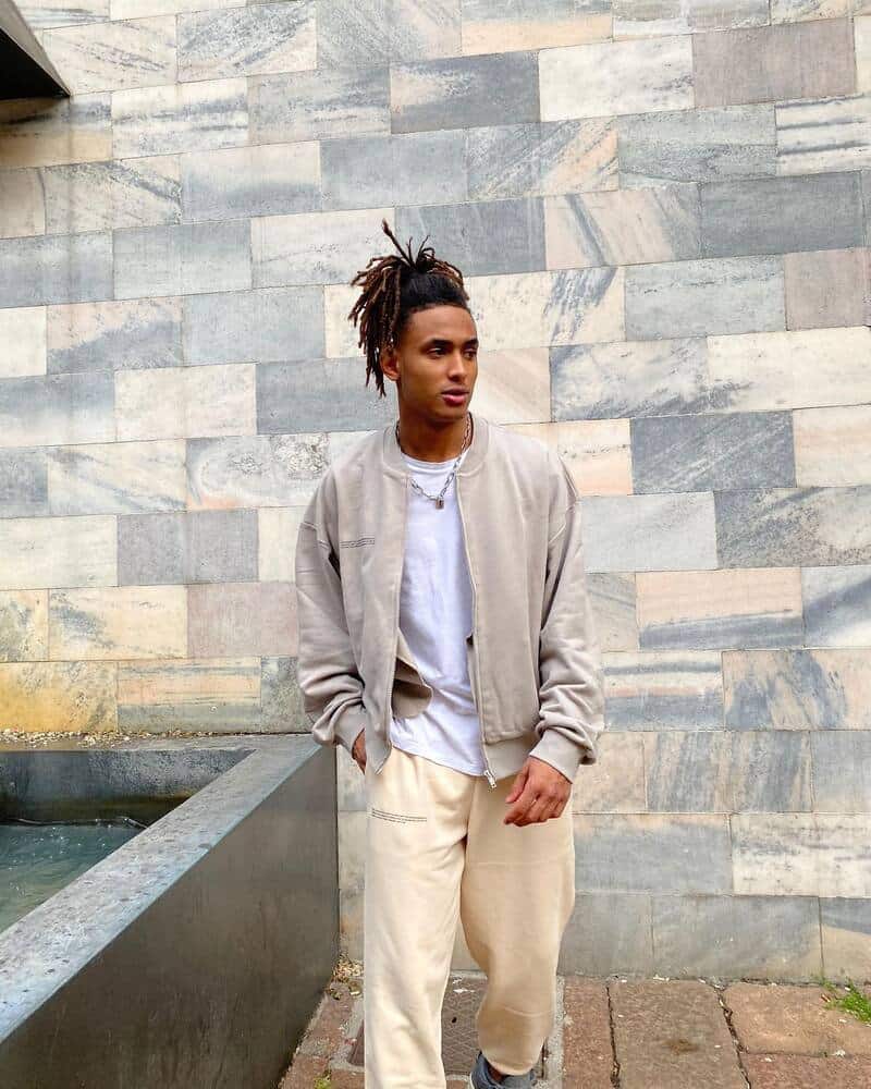 man in a light grey bomber jacket by Pangaia