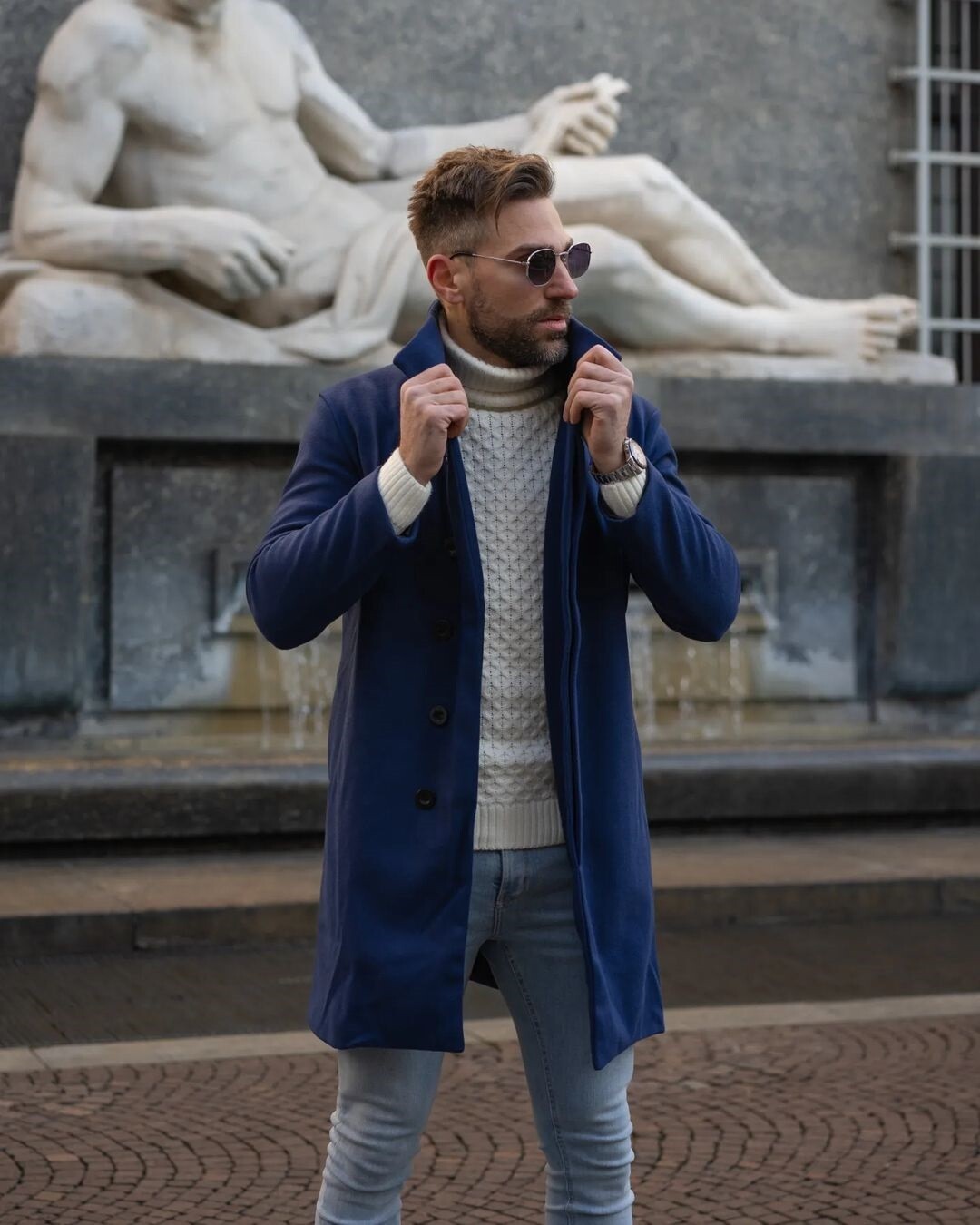 man holding the colar of his blue pea coat by Coofandy