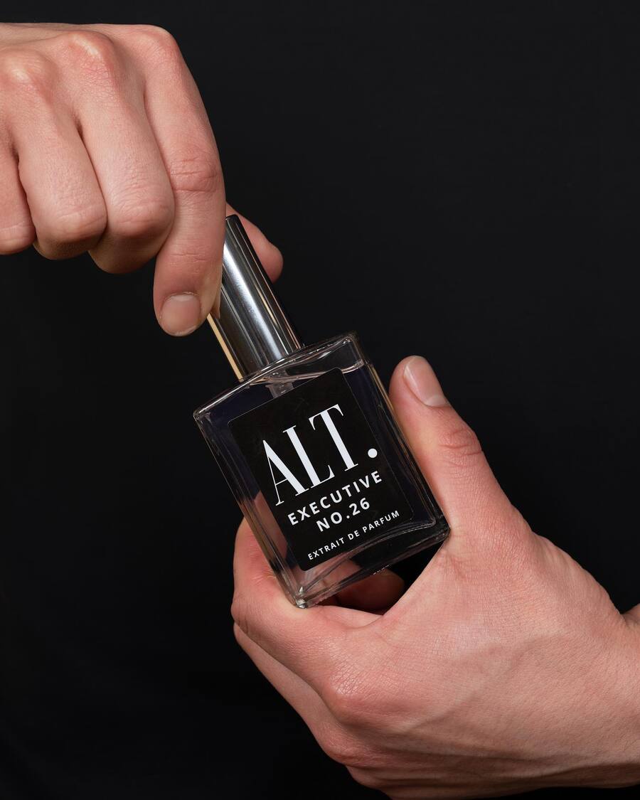 holding a bottle of Executive cologne by Alt Fragrances