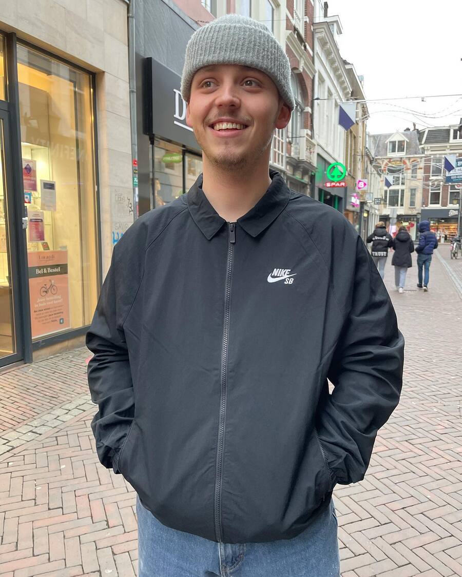 man wearing a beanie and a coach jacket by nike