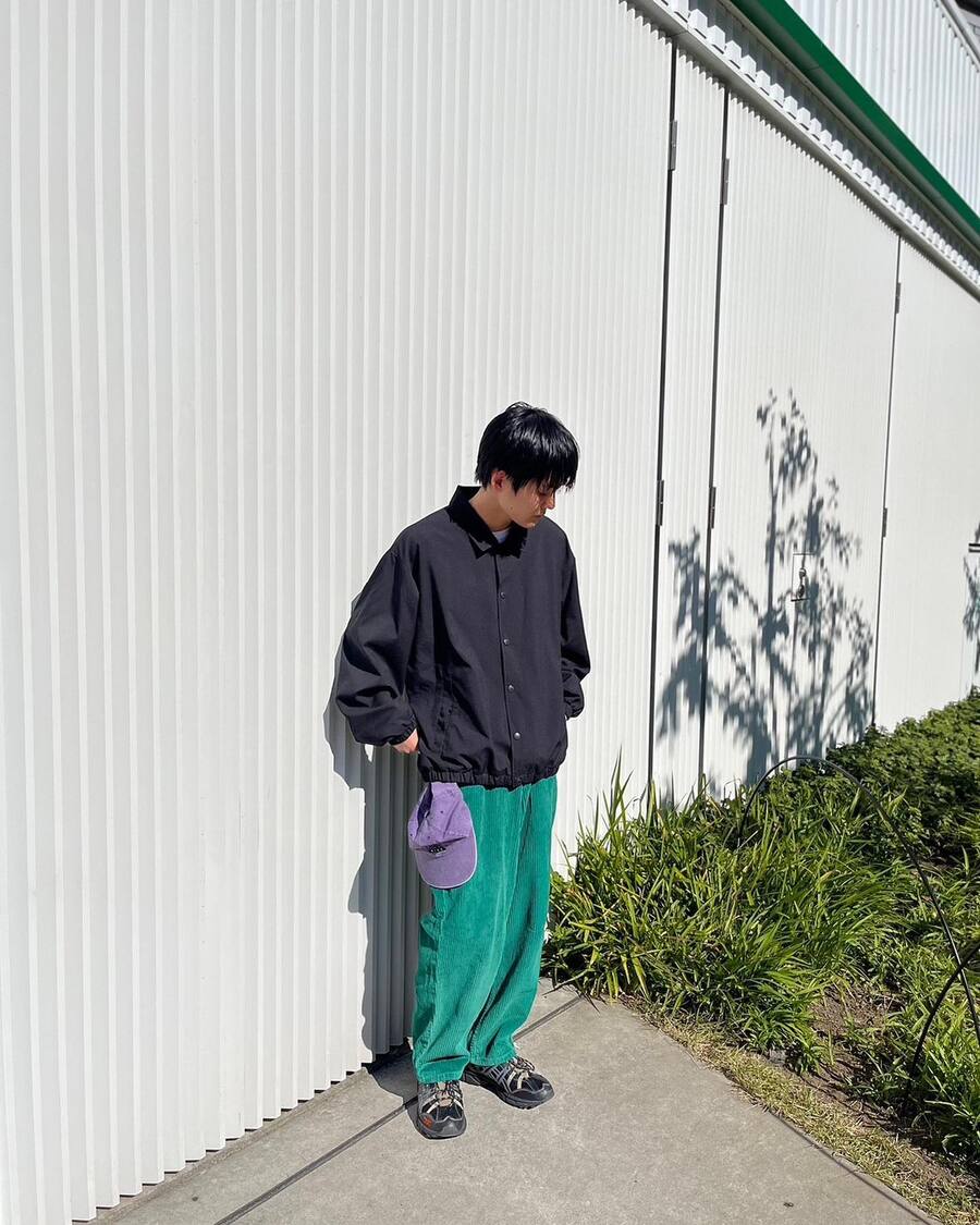 man wearing a coach jacket and a baggy corduroy pants