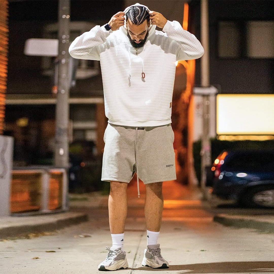 man putting on a hood of a waffle knit hoodie