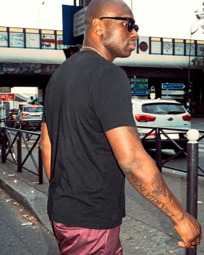 A man walking on the street wearing a black cdlp t-shirt