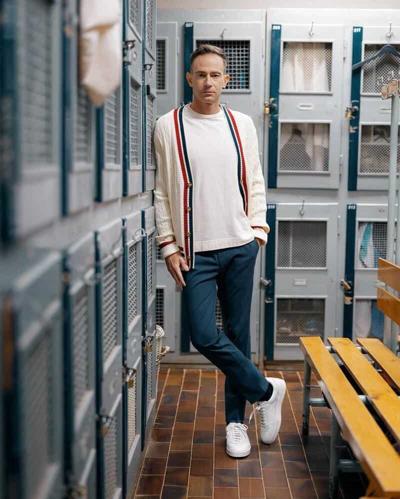 man in a locker room wearing a tennis inspired outfit