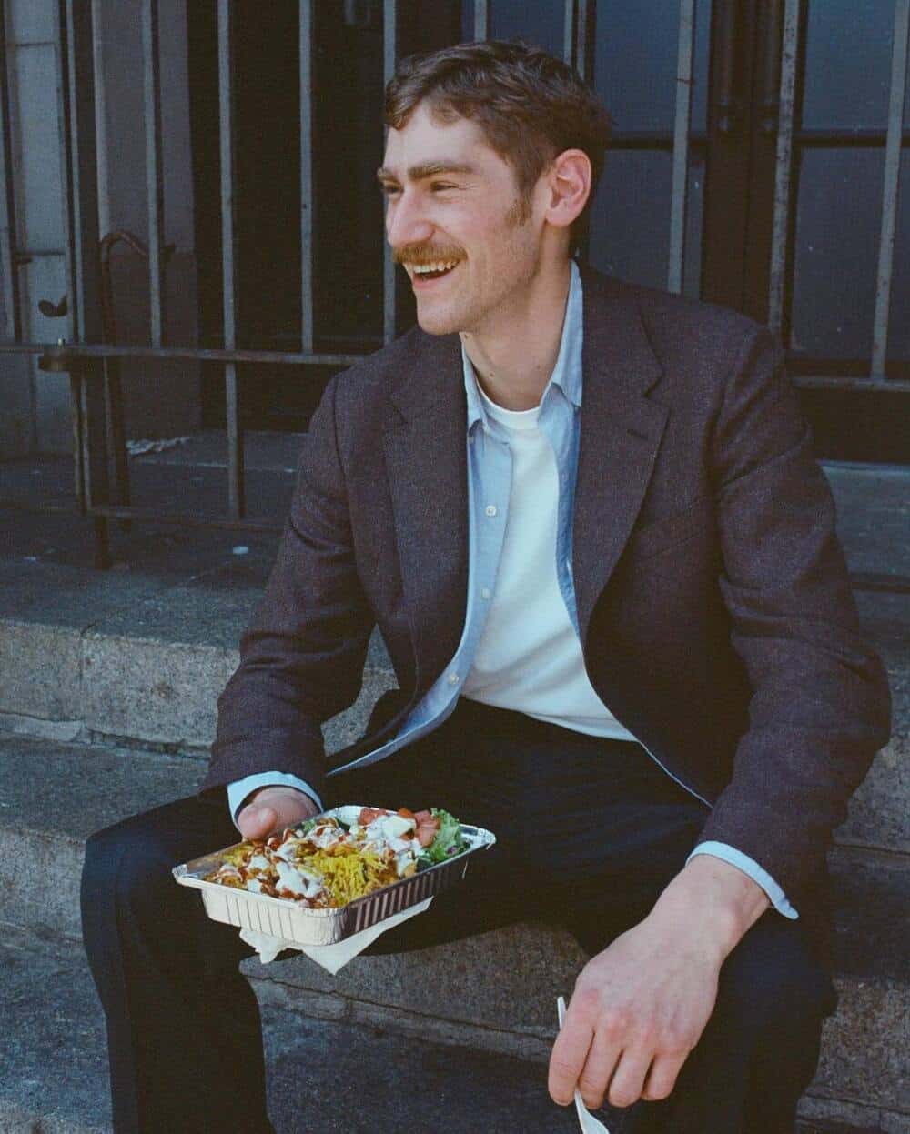 man with food sittig on the stairs