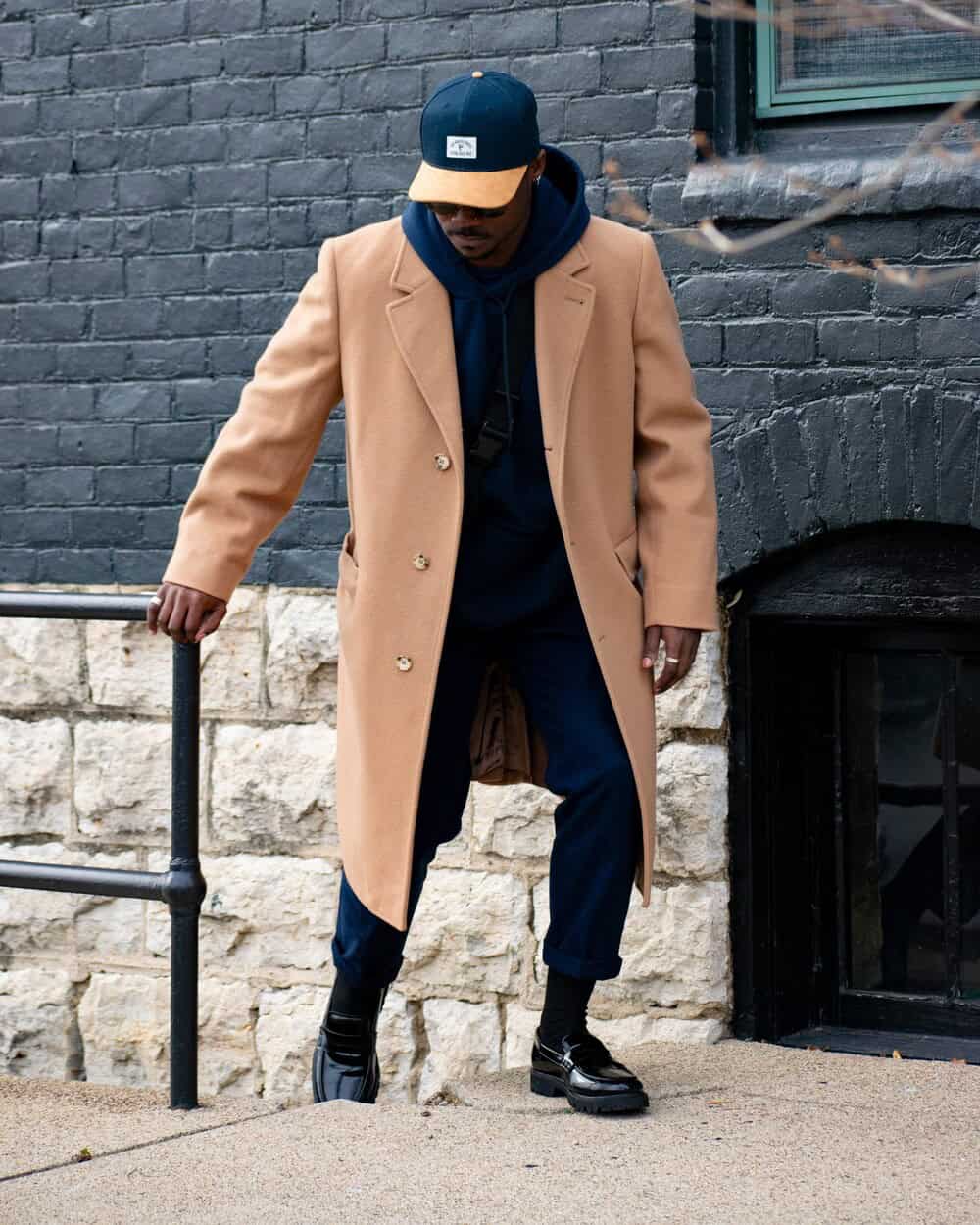 man wearing an overcoat climbing the stairs