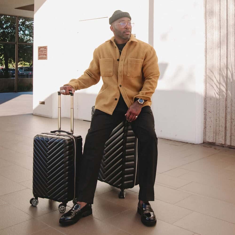 man with luggage wearing a beanie and an overshirt