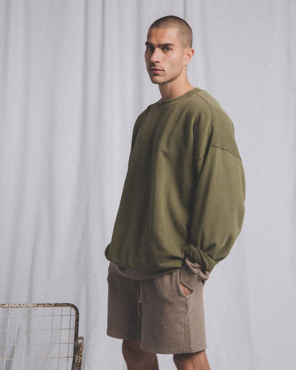 man wearing an olive green crew neck jumper by Elwood