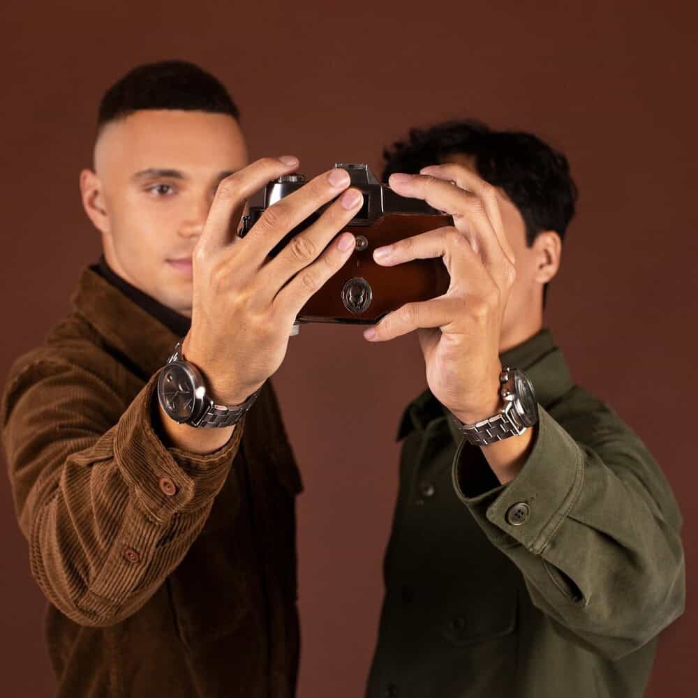 two men taking a selfie using a retro style camera