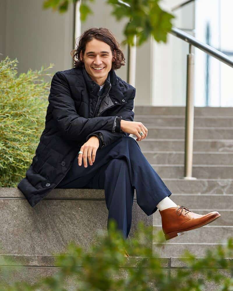 man sitting on a plant box by the stairs