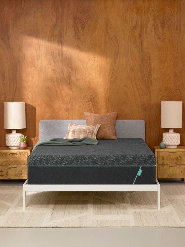 grey mattress on a white bedframe against a wooden wall