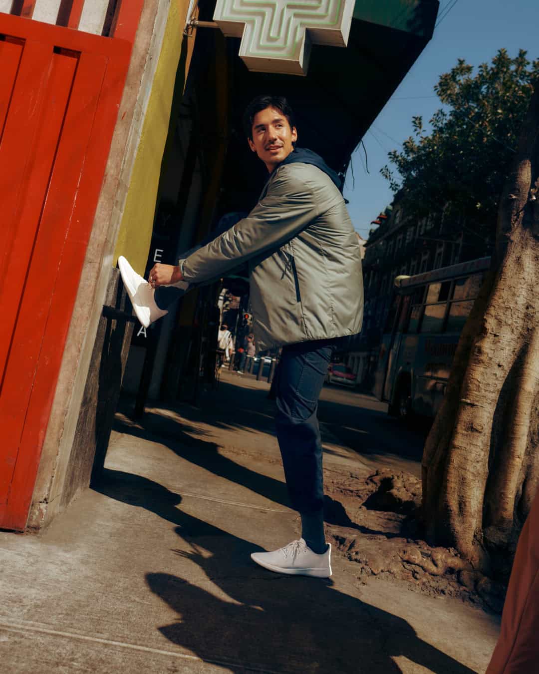 man tying a shoelace of a white sneaker by allbirds