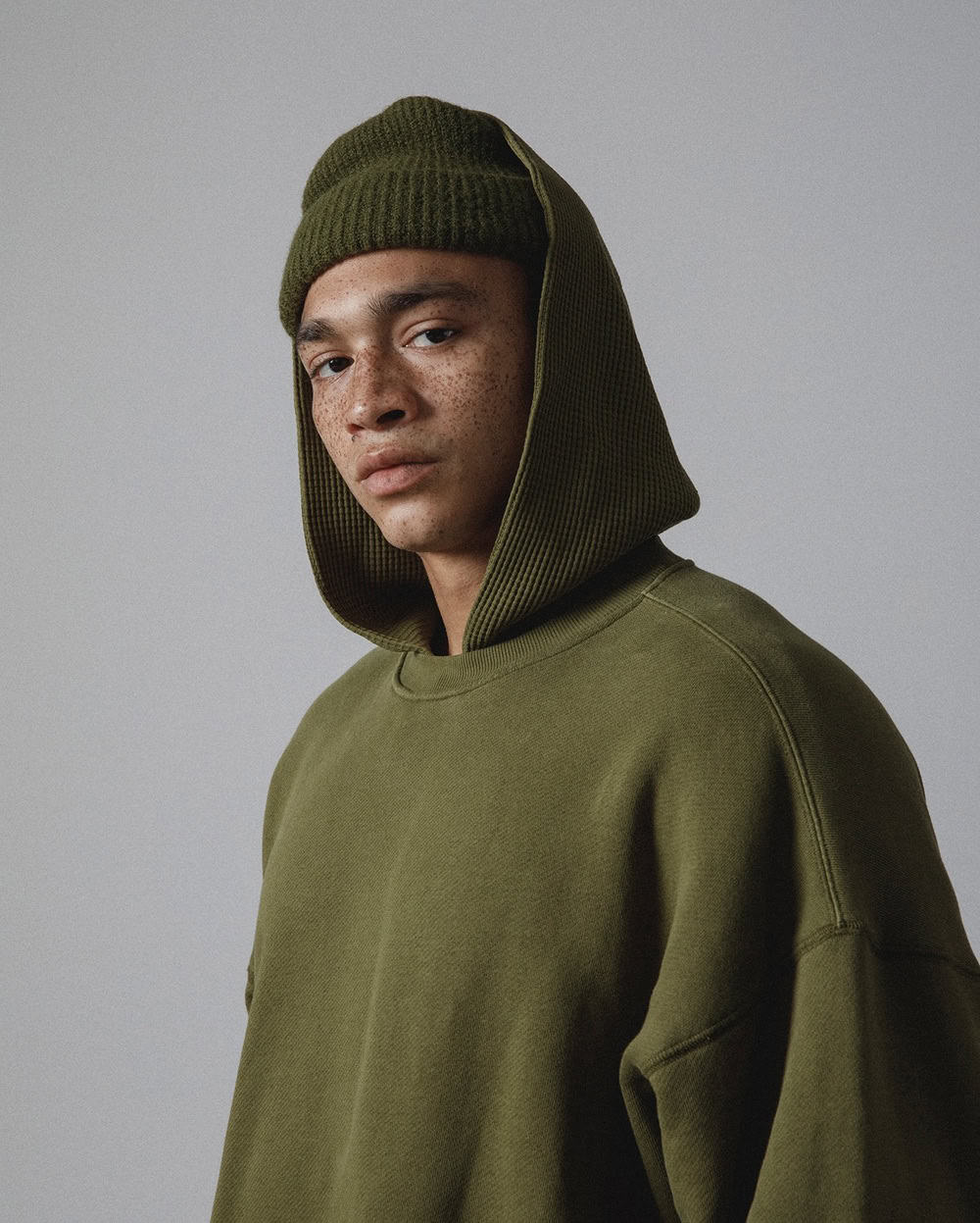 man wearing an olive green beanie and hoodie