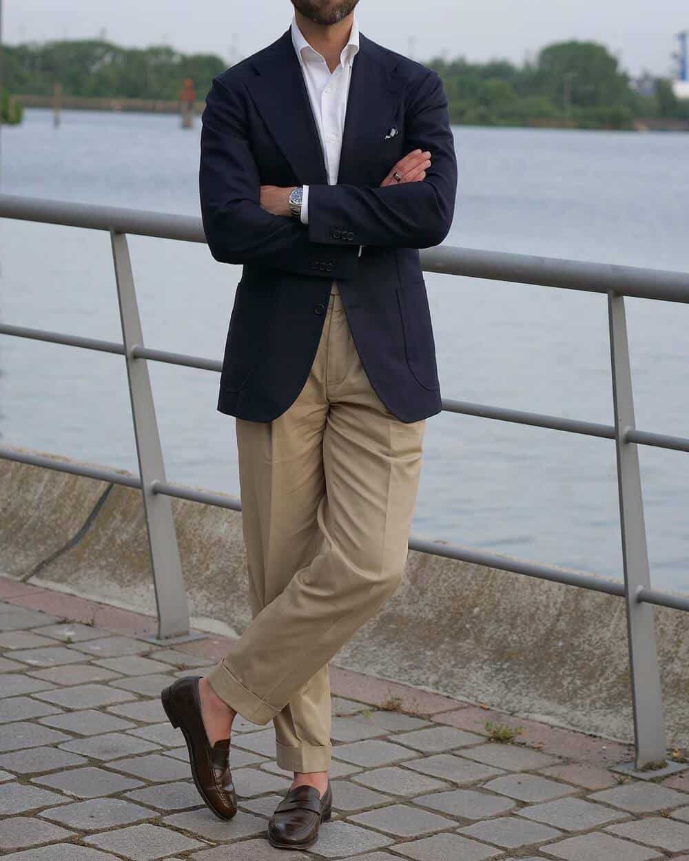 man wearing a navy blazer khaki pants and brown loafers