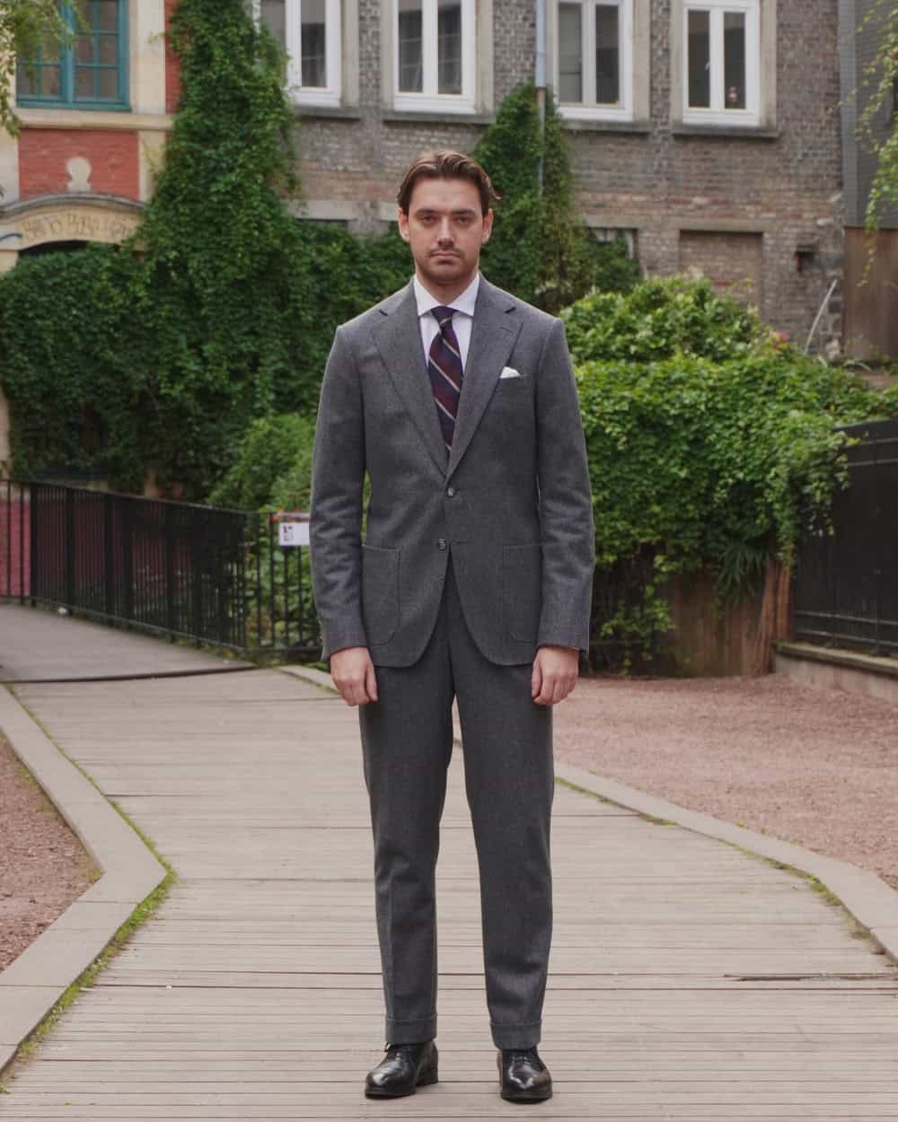 man wearing a gray suit and black oxford shoes