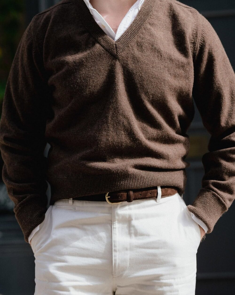 man wearing brown v-neck sweater and white pants