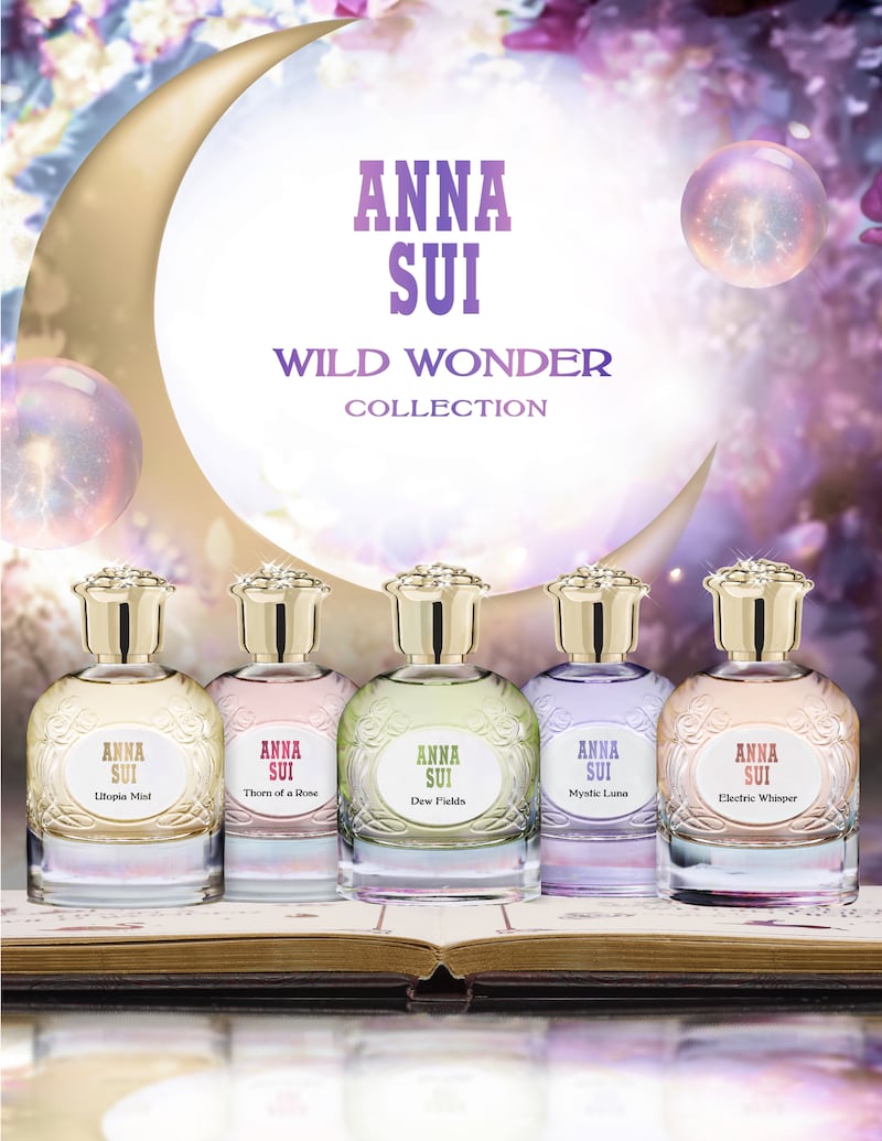 The five Anna Sui Wild Wonder fragrances sit on an open book in front of bubbles and a crescent moon.