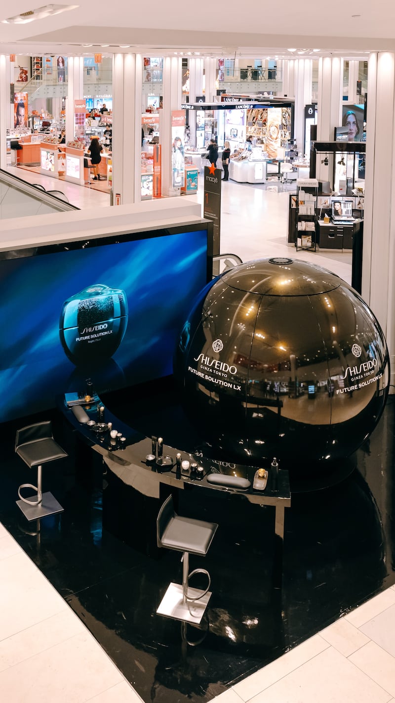 In the middle of the 34th street Macy's store's beauty floor is a car-sized orb wrapped in black and gold Shiseido branding, flanked by makeup counters.